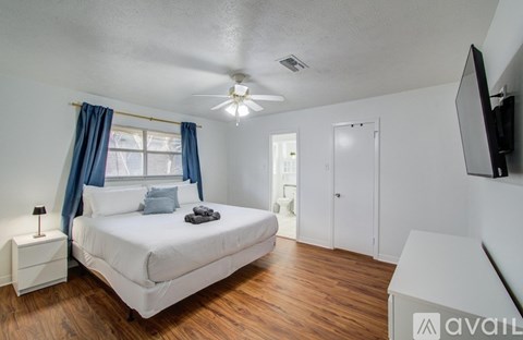 A bedroom with a bed, nightstand, and a television.