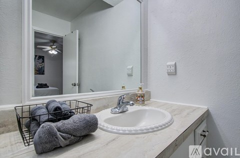 A bathroom with a white sink and a mirror.