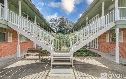 A white staircase connects two balconies in a building.