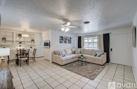 A living room with a couch, chairs, and a dining table.