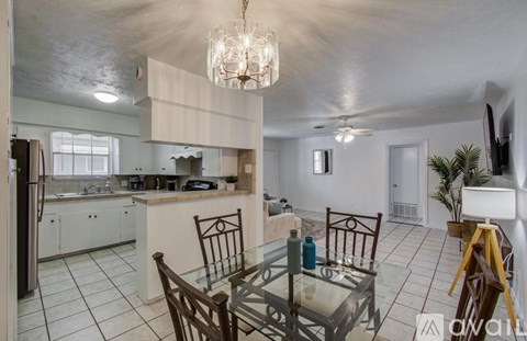 A kitchen with a dining table and chairs.