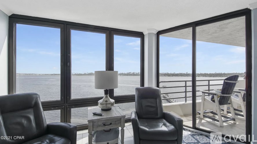 A room with a view of the water through large windows.