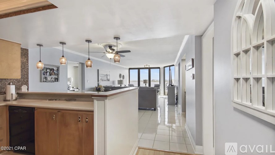 A kitchen with a fan and a fridge.