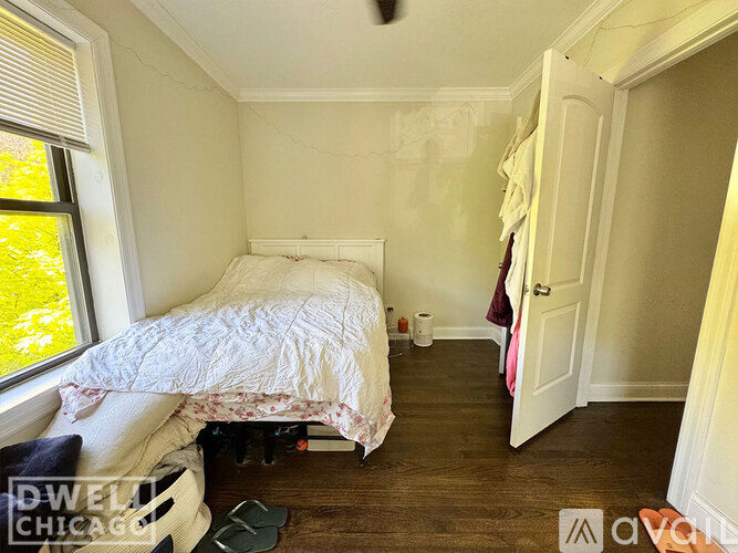 A bedroom with a bed, a window, and a door.