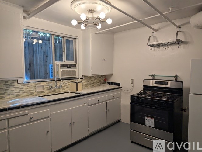 A kitchen with a stove top oven and cabinets.