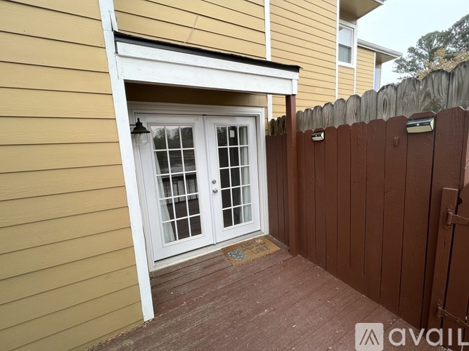 A white door with a glass window is on a yellow house.
