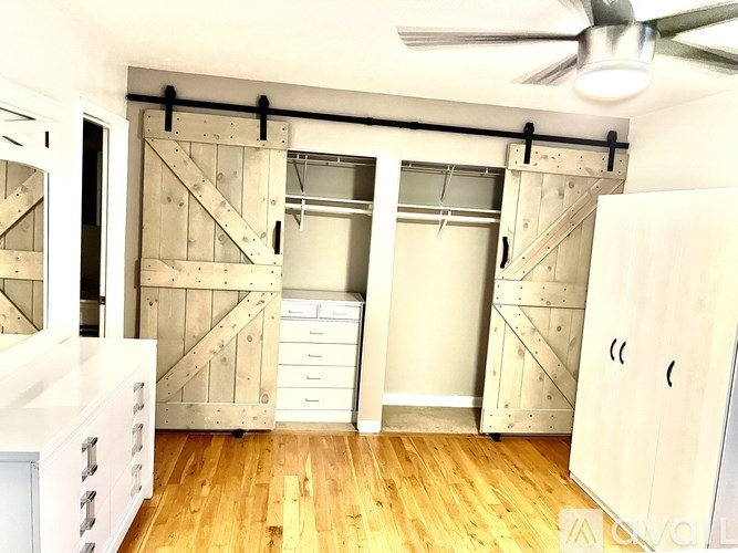 A room with a ceiling fan and wooden floors.