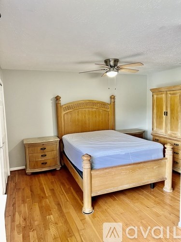 A bedroom with a bed, nightstand, and dresser.