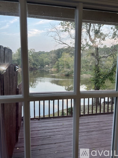 A view from a window looking out to a lake and trees.