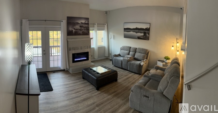 A living room with a grey couch and a fireplace.