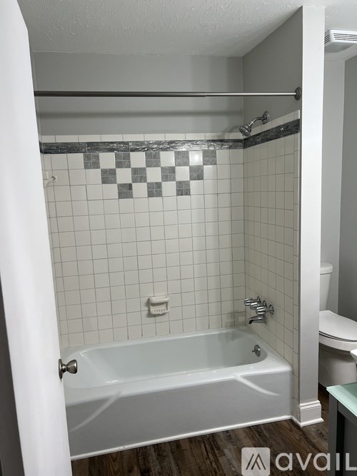 A white bathroom with a bathtub and a toilet.