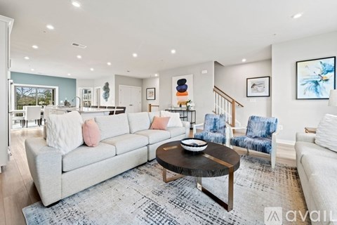 A living room with a grey couch, a coffee table, and a painting on the wall.