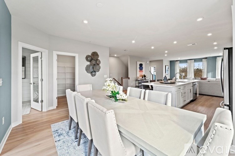 A modern dining room with a long table and chairs.