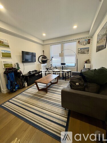 A living room with a couch, a coffee table, and a television.