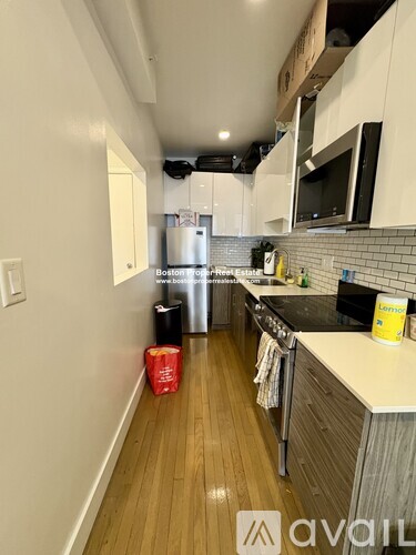 A kitchen with wooden floors and white walls.