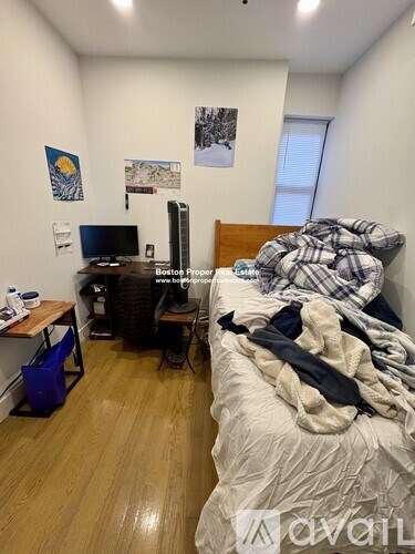 A bedroom with a bed, desk, and chair.