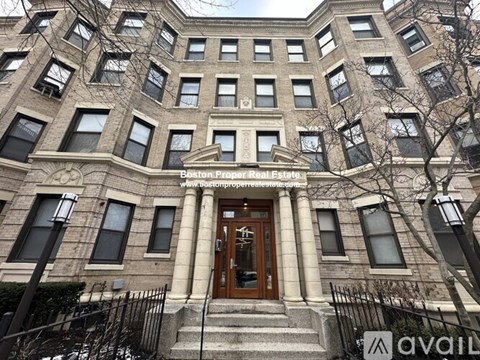 A large, multi-story building with a central entrance and a balcony above the doorway.