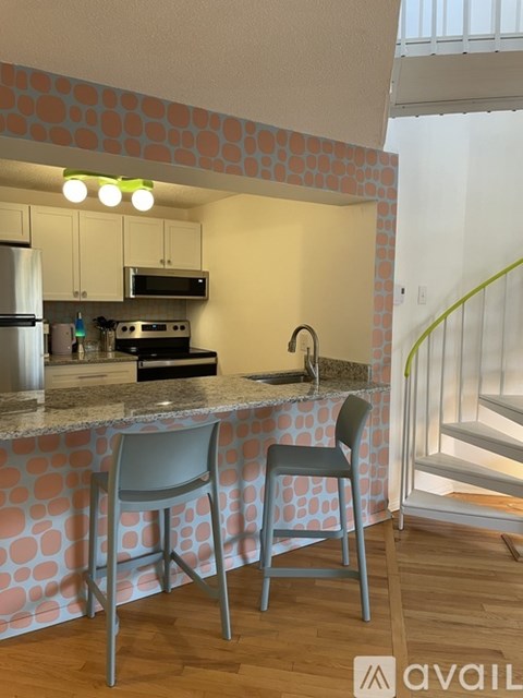 A kitchen with a bar area and two chairs.
