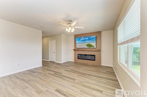A spacious living room with a television and a fireplace.