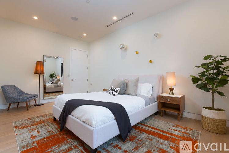 A bedroom with a large bed and a chair.