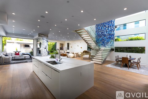 A modern kitchen with a white island and wooden floors.