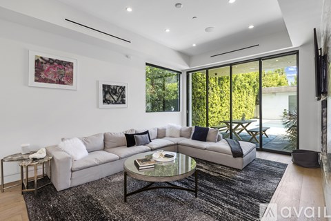 A modern living room with a grey sofa and a glass coffee table.