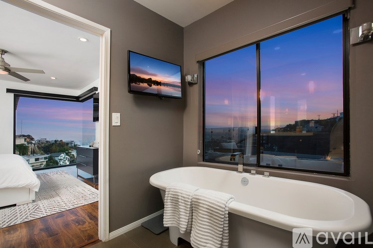 A bathroom with a large tub and a view of the city.