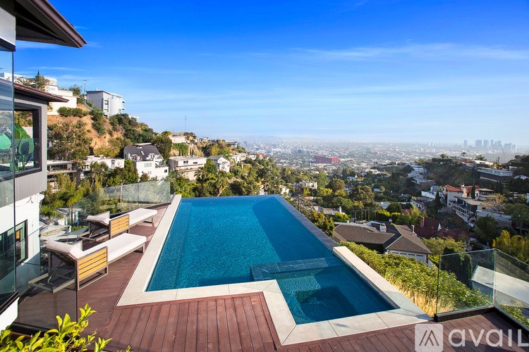 A swimming pool on a terrace with a view of a city.