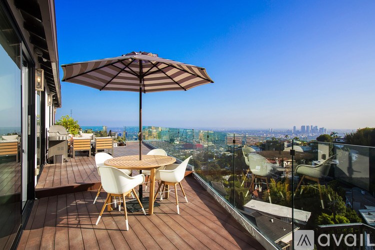 A patio with a table and chairs overlooking a cityscape.