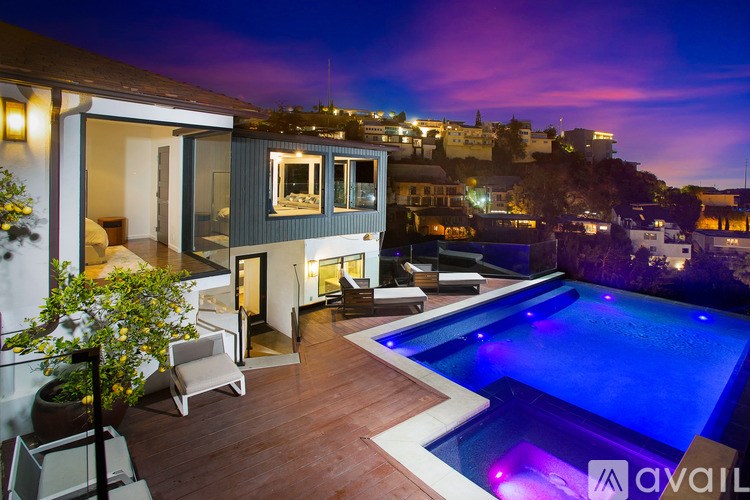 A modern house with a pool at night.