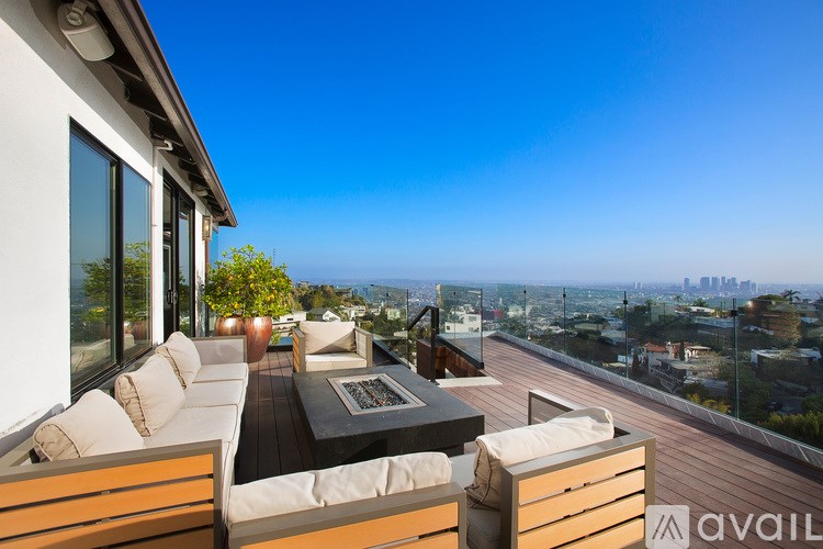 A patio with a table and chairs overlooking a cityscape.
