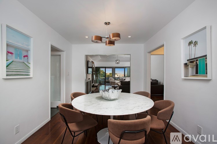 A modern dining room with a round table and chairs.