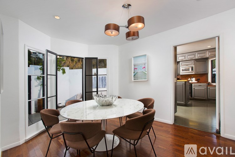 A dining room with a round table and chairs.
