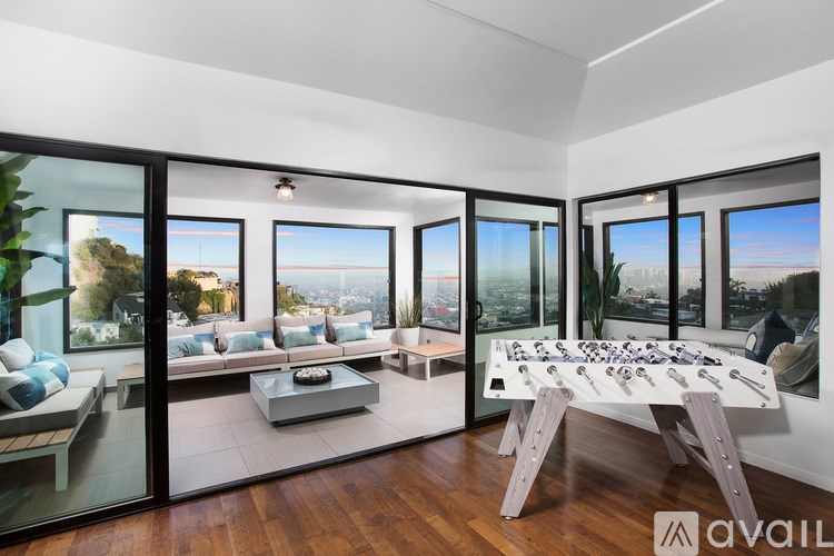 A modern living room with a view of the cityscape outside the large windows.