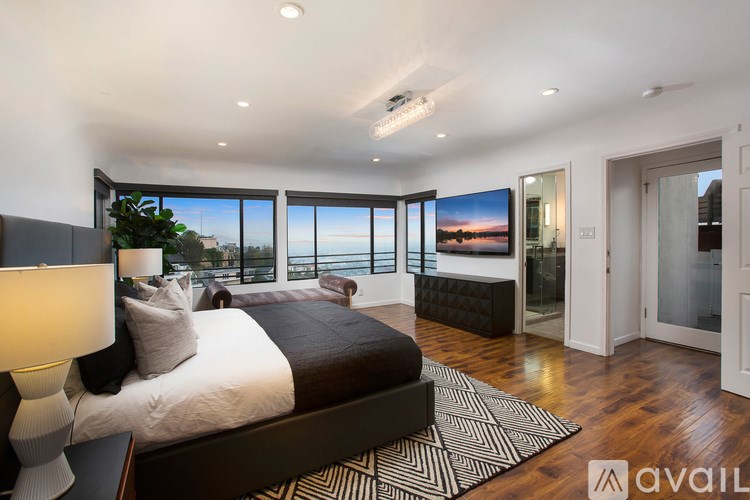 A bedroom with a large bed and a view of the city.