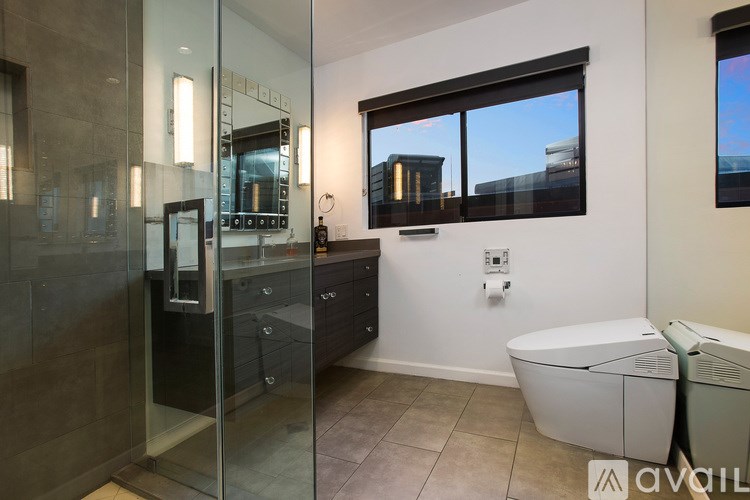 A bathroom with a glass shower door and a large mirror.
