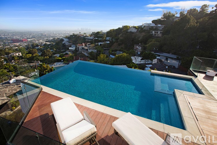 A swimming pool with a chair and a table in front of it.
