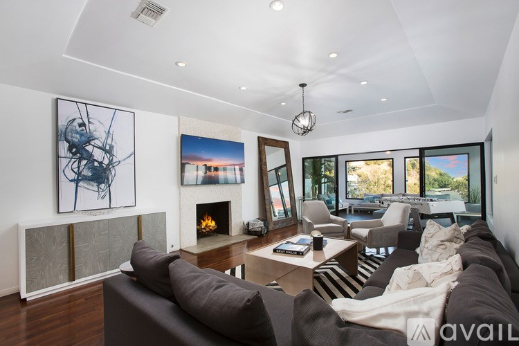 A modern living room with a fireplace and a large painting on the wall.
