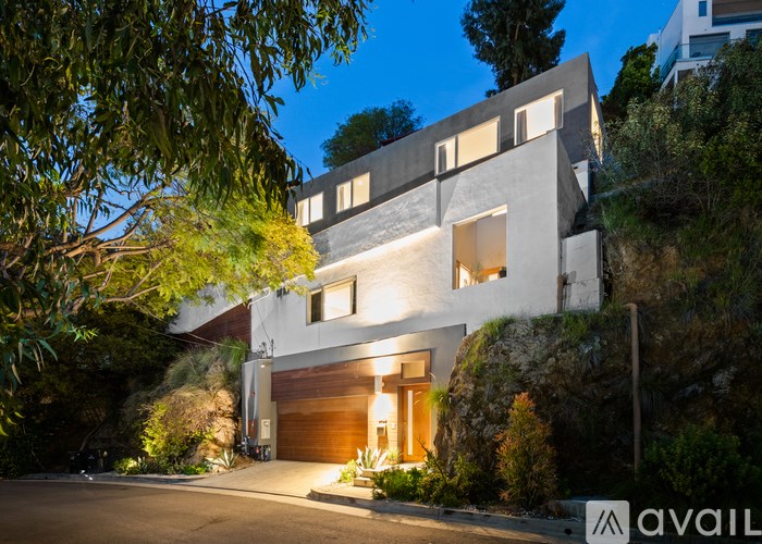 A modern house with a large driveway and garage is available for purchase.