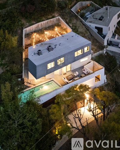 A modern house with a pool at night.