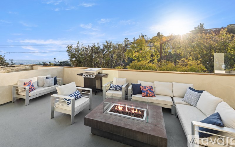 A patio with a fire pit and couches.