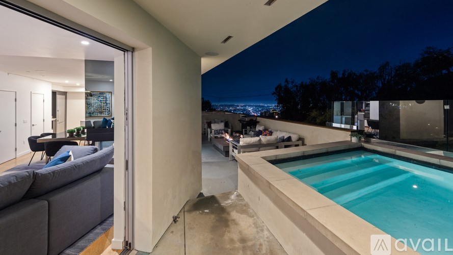 A modern house with a pool at night.