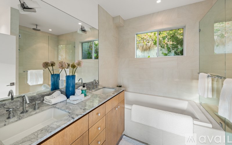 A bathroom with a tub, sink, and mirror.