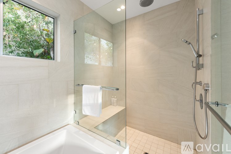 A bathroom with a glass shower door and a white bathtub.