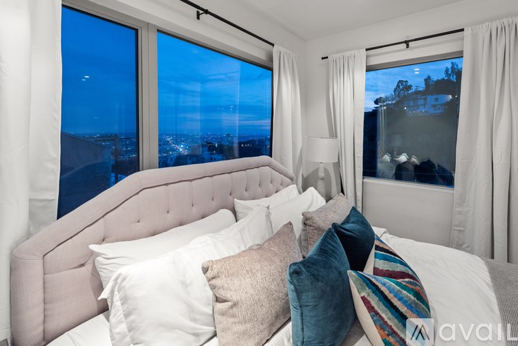 A bedroom with a large bed and a view of the city.
