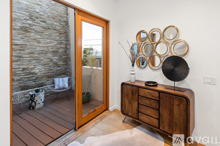 A room with a wooden dresser and mirrors on the wall.