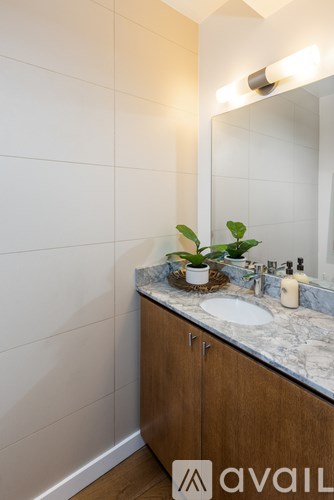 A bathroom with a marble countertop and a mirror above it.