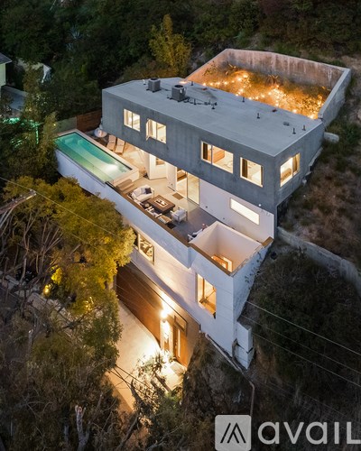 A modern house with a pool at night.