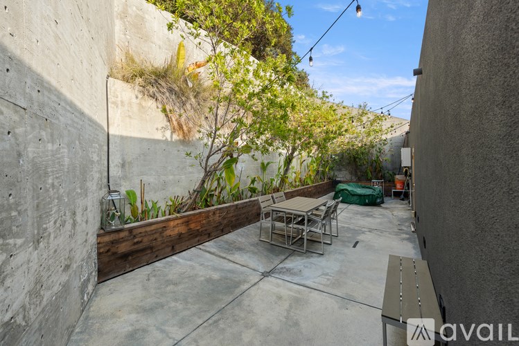 A patio with a table and chairs is surrounded by concrete walls.