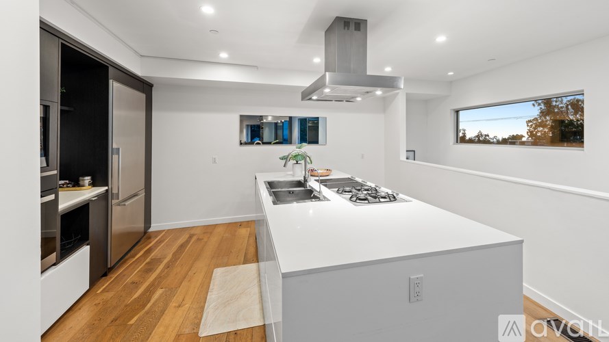 A modern kitchen with a large island and stainless steel appliances.